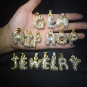 Vue macro des pendentifs lettres 3D bulles avec placage or et zircons scintillants
