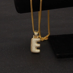 Détail du pendentif lettre E en plaqué or serti de pierres de zircone cubique