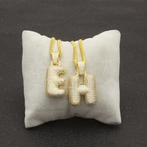 Détail des lettres Hip Hop dorées E et H serties avec chaîne cubaine sur velours gris