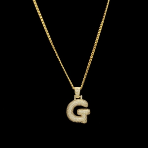 Gros plan du pendentif lettre G dorée hip hop avec micro-pavage de zircons cubiques
