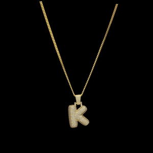 Détail du pendentif lettre K bulle glacé avec oxydes de zirconium sur une chaîne dorée