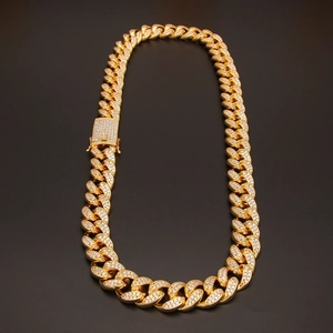 Detailed macro view of 20mm gold iced out Cuban link chain with paved zircon buckle