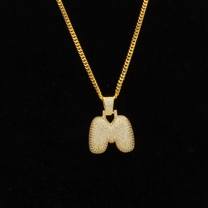 Détail du pendentif lettre M doré serti de zircons avec chaîne cubaine style hip-hop