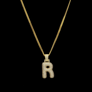 Gros plan détaillé du pendentif lettre R serti de zircons sur une chaîne cubaine