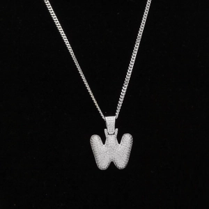 Gros plan sur un collier hip-hop argenté avec pendentif lettre W serti de zircons blancs