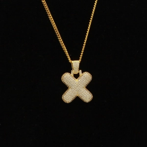 Détail du pendentif lettre X hip-hop doré serti de zircons cubiques sur une chaîne gourmette