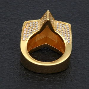 Gros plan d'une bague hip hop dorée ornée de diamants pavés sur fond de cuir noir