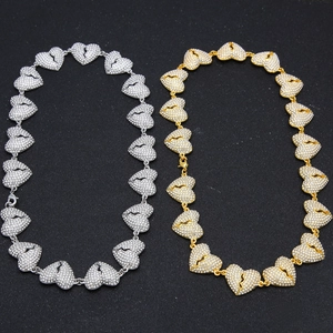 Macro detail of iced out broken heart linked necklace in gold and silver finish