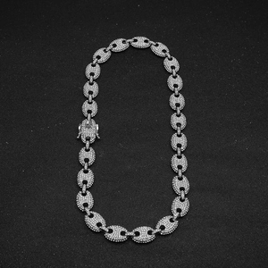 Macro detail of iced-out silver coffee bean link necklace with pave zircons and secure clasp