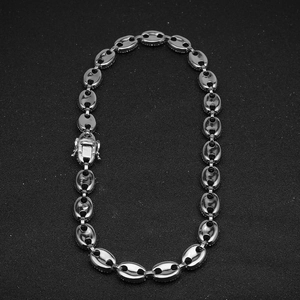 Macro detail of silver coffee bean link necklace featuring pave-set sparkling crystals
