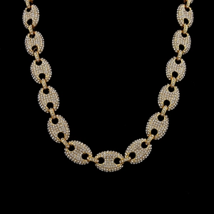 Close-up of golden hip hop mariner link chain with iced out crystal pavé detailing