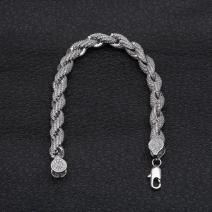 Macro-opname van zilveren gedraaide armband met witte zirkoon micro-pave en karabijnsluiting