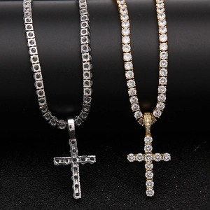 Close-up of gold and silver iced out cross pendants on micro paved tennis chains