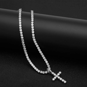 Close-up of silver-tone hip hop tennis chain and iced-out cross pendant with cubic zirconia