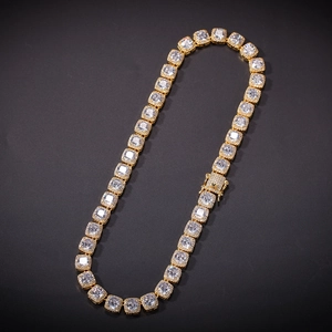 Macro shot of gold hip-hop chain showing square cubic zirconia stones and iced-out clasp
