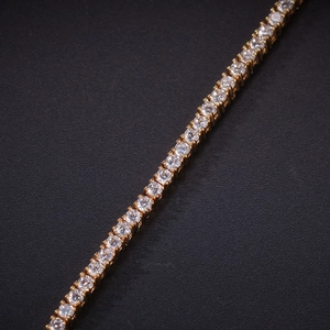 Detailed macro view of 2mm zircon tennis bracelet with gold plating and four-prong setting