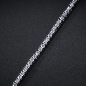Macro detail of silver tennis bracelet featuring 2mm round-cut cubic zirconia in claw setting