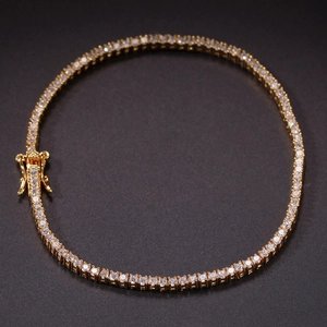 Classic gold tennis bracelet with 2mm round zircon stones and secure clasp on black background
