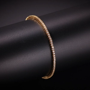Macro shot of gold tennis bracelet with 2mm round cubic zirconia on a black display stand