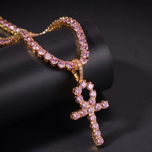 Detailaufnahme des goldfarbenen Ankh-Anhängers mit rosa Zirkonia auf Tenniskette