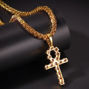 Nahaufnahme des Hip-Hop-Ankh-Kreuzanhängers mit rosa Zirkonia auf einer goldenen Tenniskette