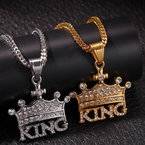 Close-up of gold and silver hip hop crown pendants with King lettering and rhinestones