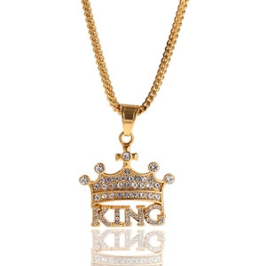 Detail shot of golden hip hop crown pendant with sparkling crystals and KING lettering