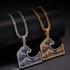 Detail of Great Wave pendants with blue and white cubic zirconia on gold and silver rope chains