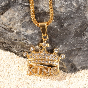 Macro shot of gold hip hop crown pendant with KING letters and inlaid rhinestones