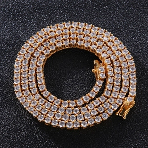 Macro shot of gold plated tennis chain with round clear cubic zirconia stones