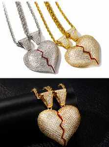 Dettaglio macro dei ciondoli a cuore spezzato con zirconi in finitura argento e oro lucido