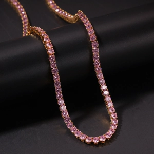 Detailaufnahme einer goldenen Tenniskette mit funkelnden runden rosa Zirkonia-Steinen