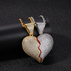 Dettaglio macro dei ciondoli a cuore magnetico in oro e argento con pietre di zircone bianco