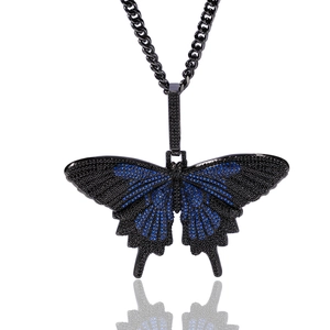 Macro-opname van vlinderhanger met zwarte en blauwe zirkonia aan dikke Cubaanse ketting