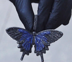 Macro-opname van grote vlinderhanger met blauwe en zwarte zirkonia steentjes