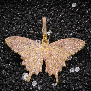 Detail van een gouden vlinderhanger met roze en witte zirkonia op zwarte stenen