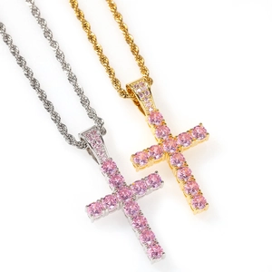 Vista macro di ciondoli a croce in oro e argento con zirconi rosa su catene a corda