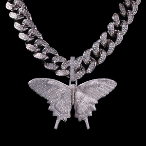 Macro-detail van sprankelende vlinderhanger op een zilveren cubaanse ketting met zirkonia's