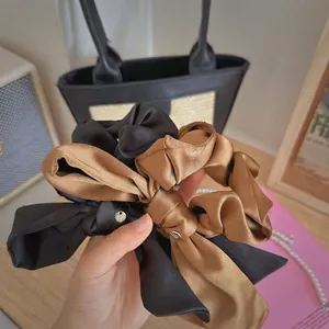 Set di elastici per capelli in raso con fiocco nero e oro champagne e ciondolo