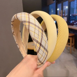 Three assorted yellow padded sponge headbands in plaid and textured matte fabric styles