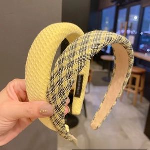 Detail of yellow waffle texture and plaid fabric headbands with handmade woven label