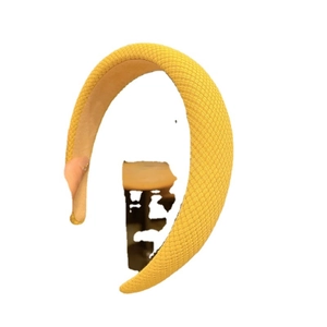 Padded bright yellow headband with woven texture for high-volume hair styling look