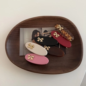 5-piece vintage metal bow hair clip set in assorted colors on a wooden tray