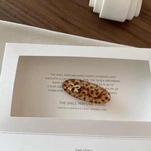 Detail view of a vintage leopard pattern hair clip with a gold metal bow on a display card