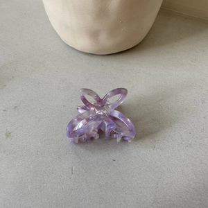 Detail of a purple marbled acetate hair claw clip with an elegant hollow butterfly design