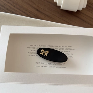 Close-up of a matte black oval hair clip with a stylish golden bow accent for women