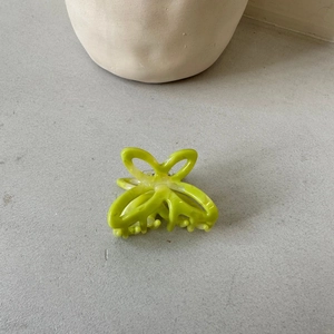 Detail of lime green hollow bow hair claw clip in translucent acetate finish