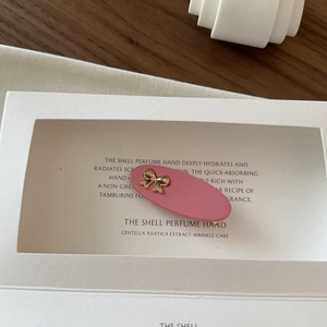 Detailed macro view of pink matte hair clip with golden metallic bow accent