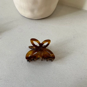 Detail view of small amber butterfly hair claw clip with hollow tortoiseshell wing design
