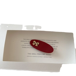 Vintage red oval hair clip with a gold metallic bow detail for women's styling